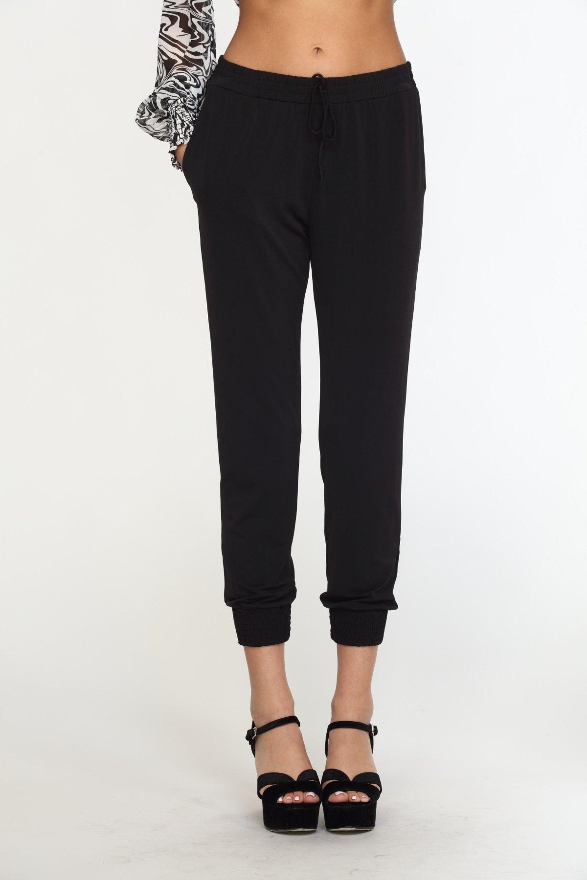 black tapered jogger pants on woman in black high heels