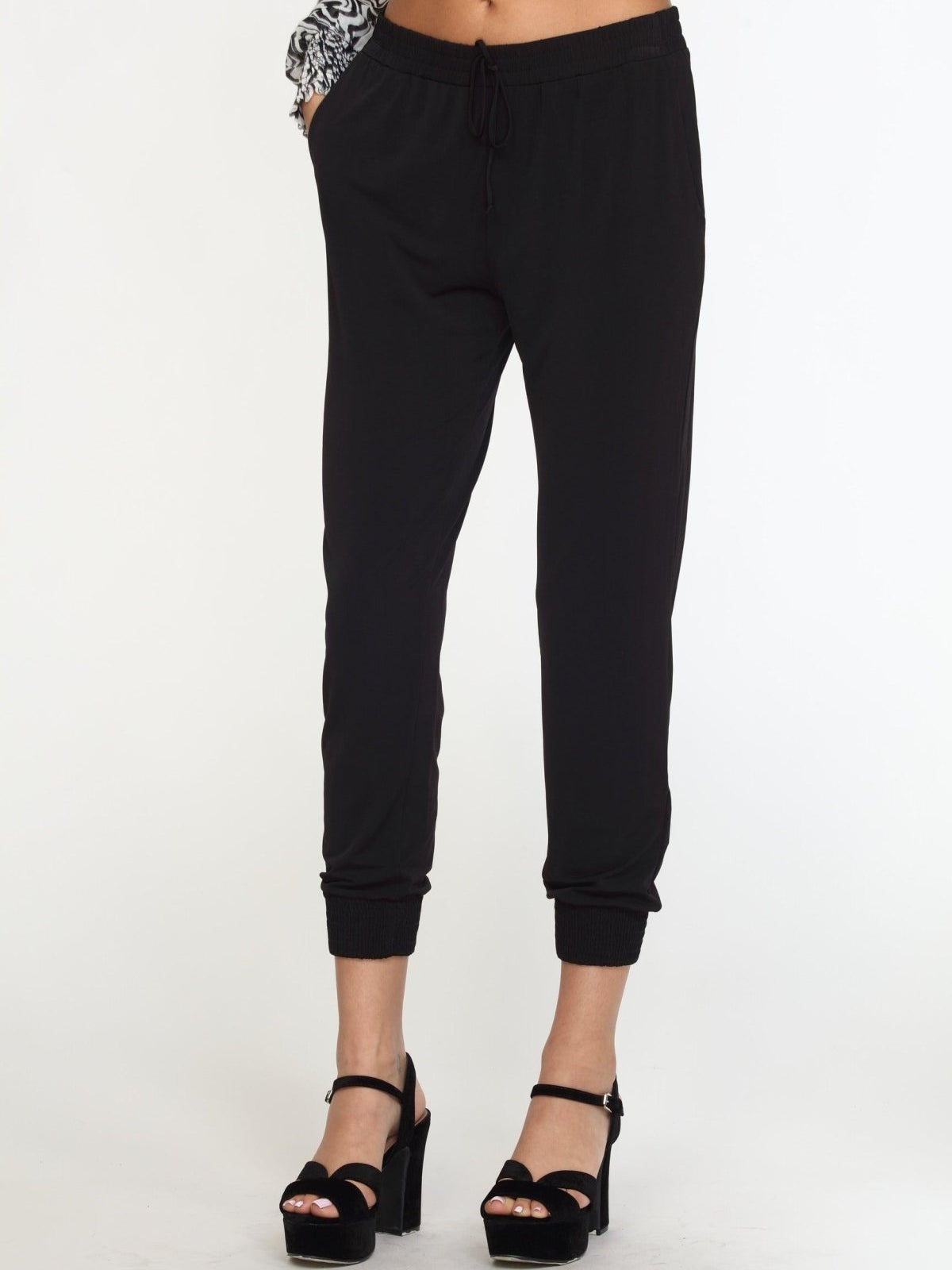 black tapered jogger pants on woman in black high heels