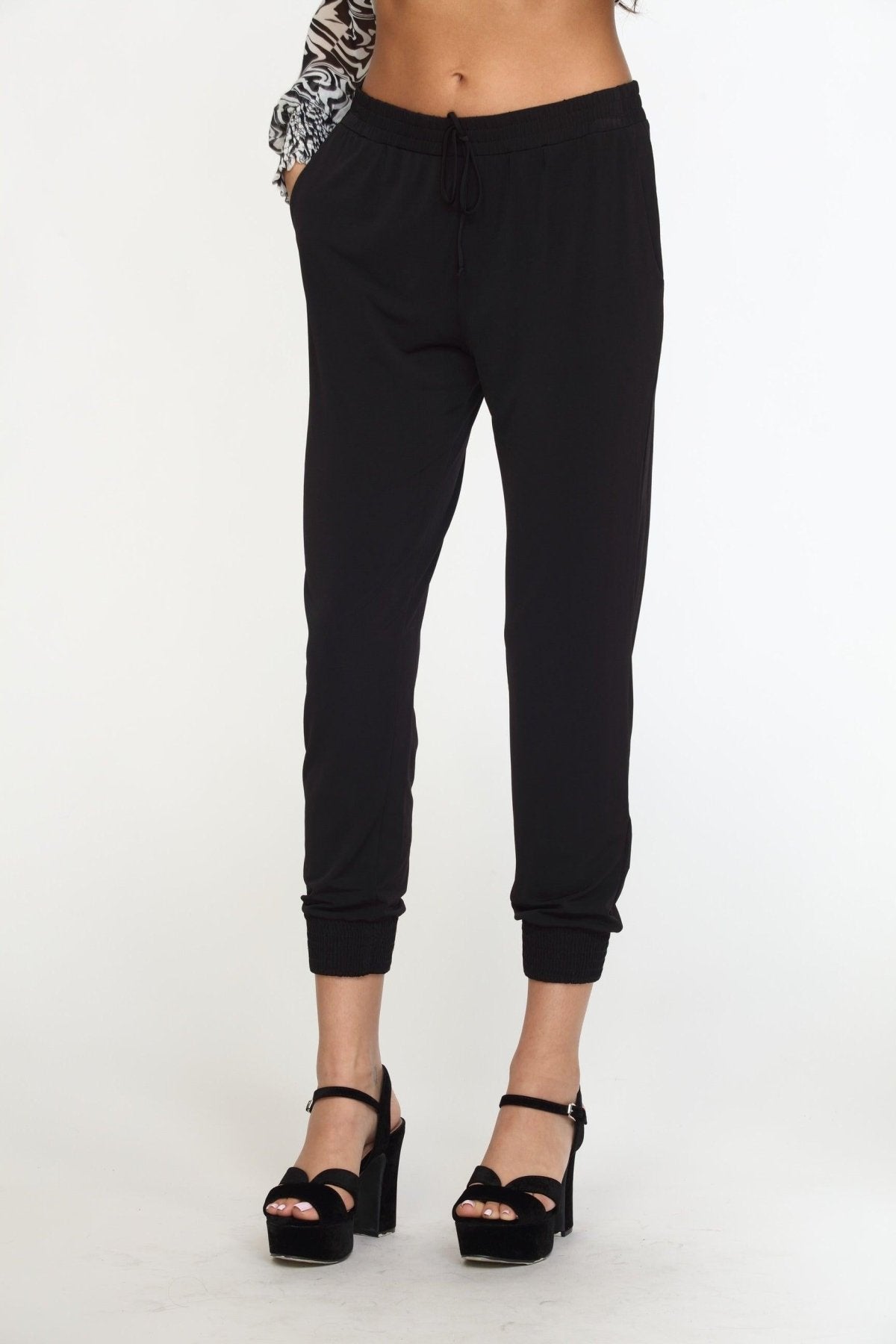 black tapered jogger pants on woman in black high heels