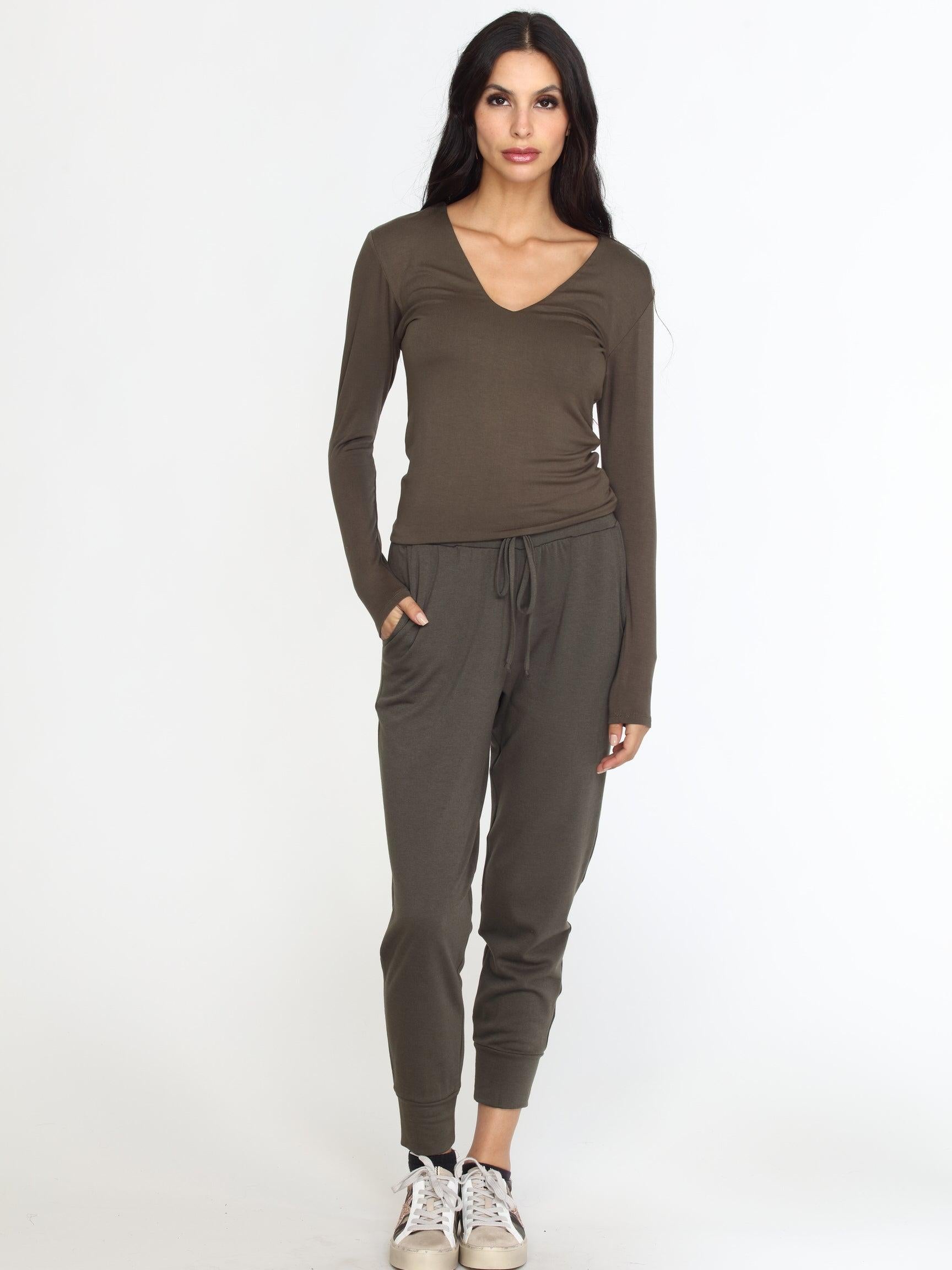 olive long sleeve vneck top on woman in olive pants and tennis shoes