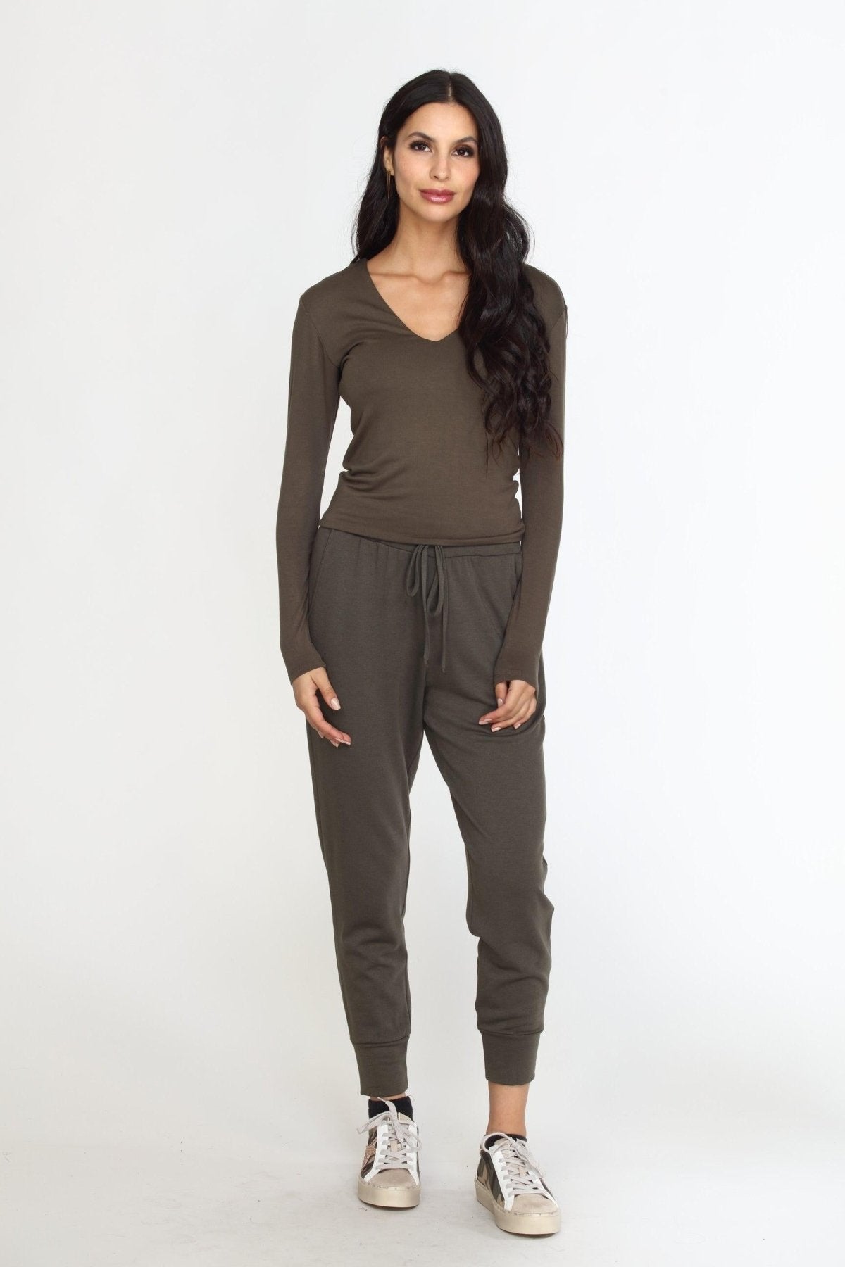 olive long sleeve vneck top on woman in olive pants and tennis shoes