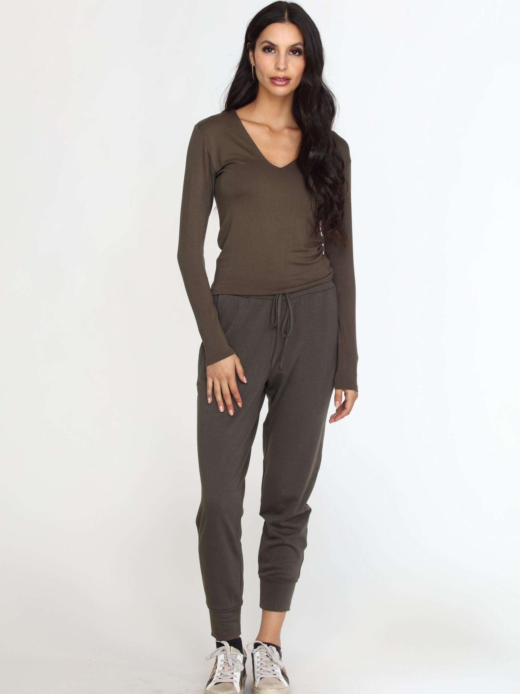 olive long sleeve vneck top on woman in olive pants and tennis shoes