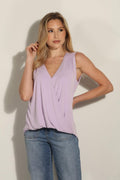 lavender sleeveless top on woman in denim pants