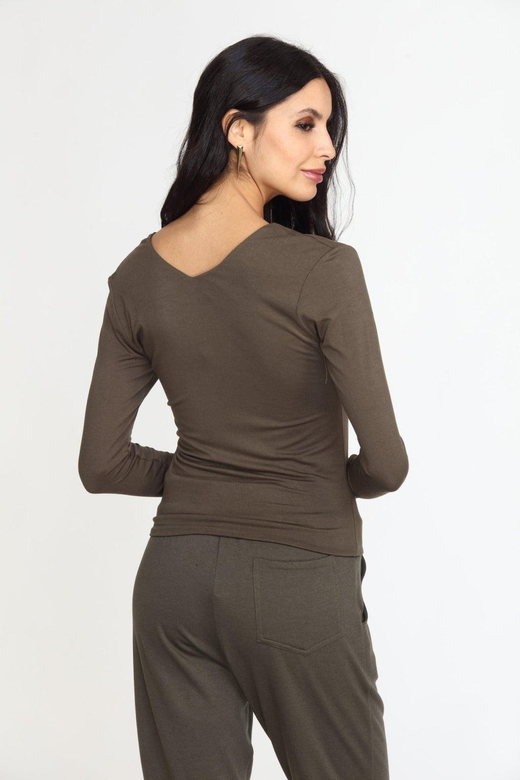 back side of olive long sleeve vneck top on woman in olive pants