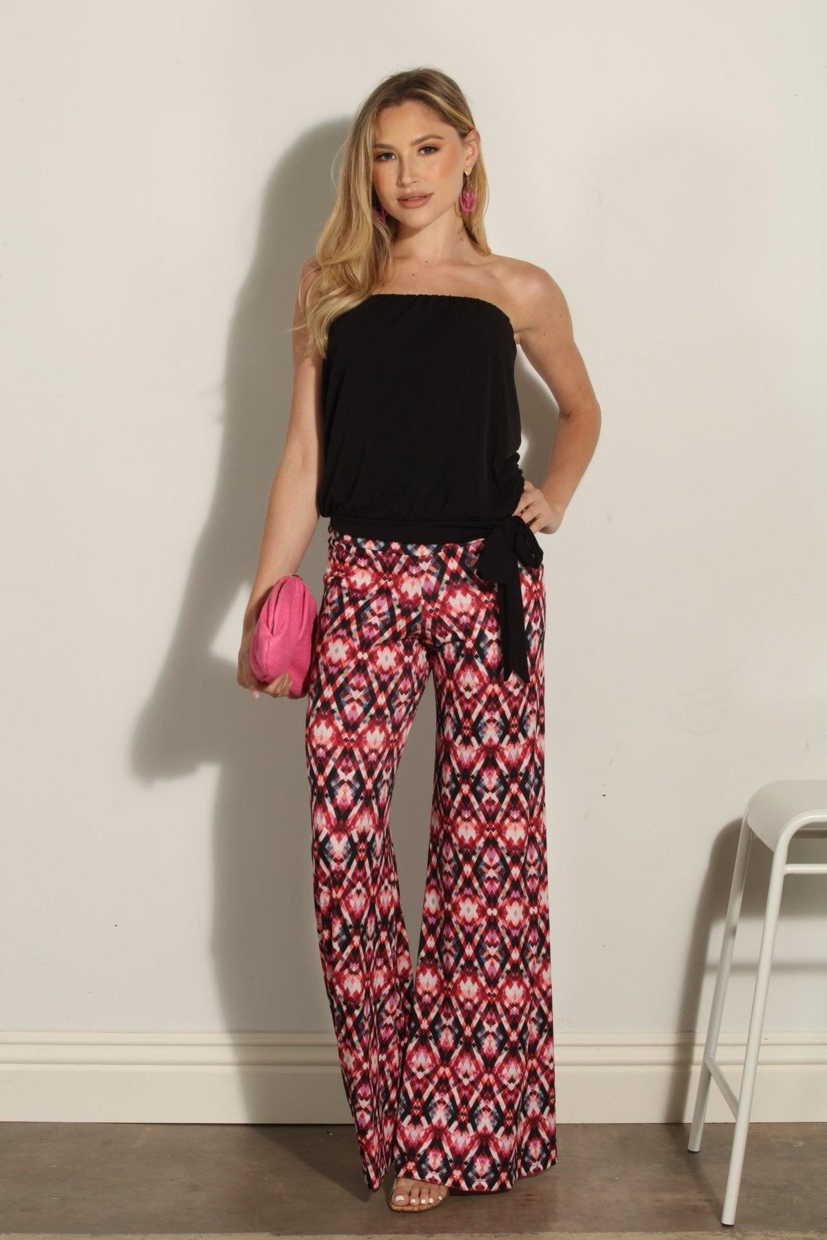 strapless top and multicolored pants on woman holding pink clutch