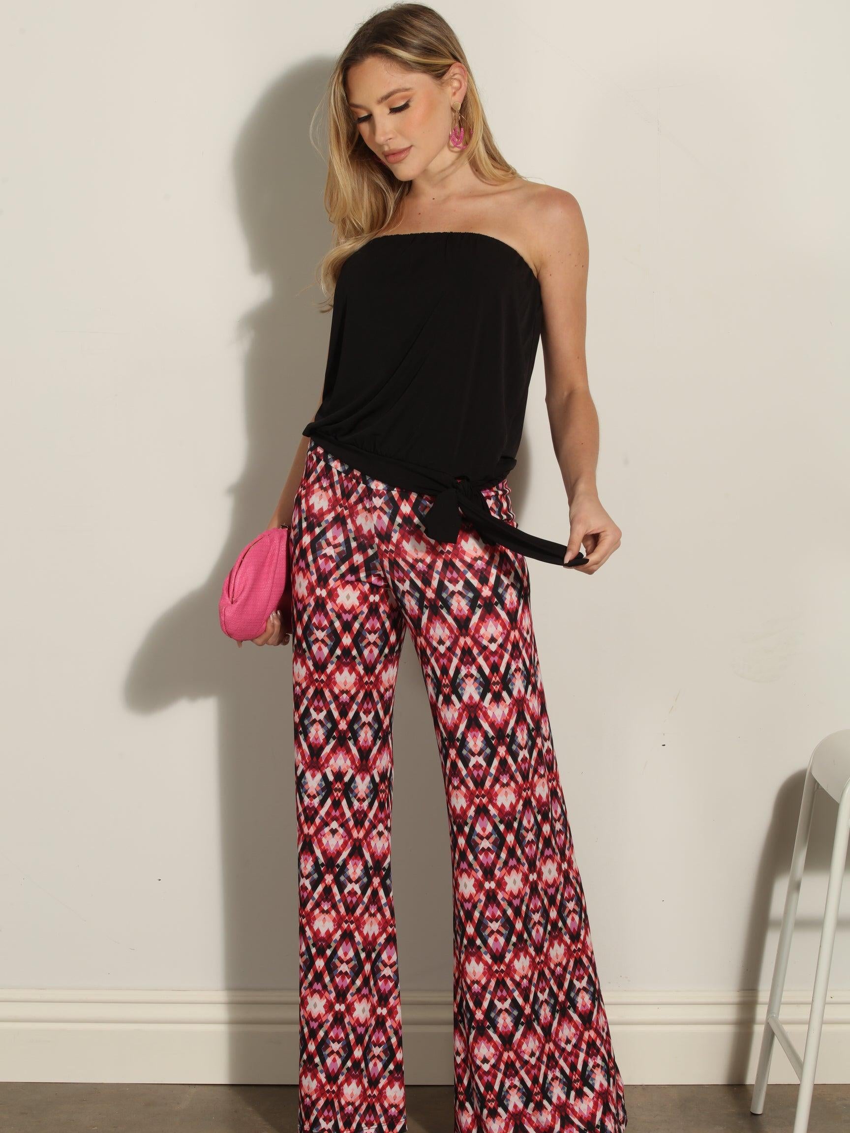 strapless top and multicolored pants on woman holding pink clutch
