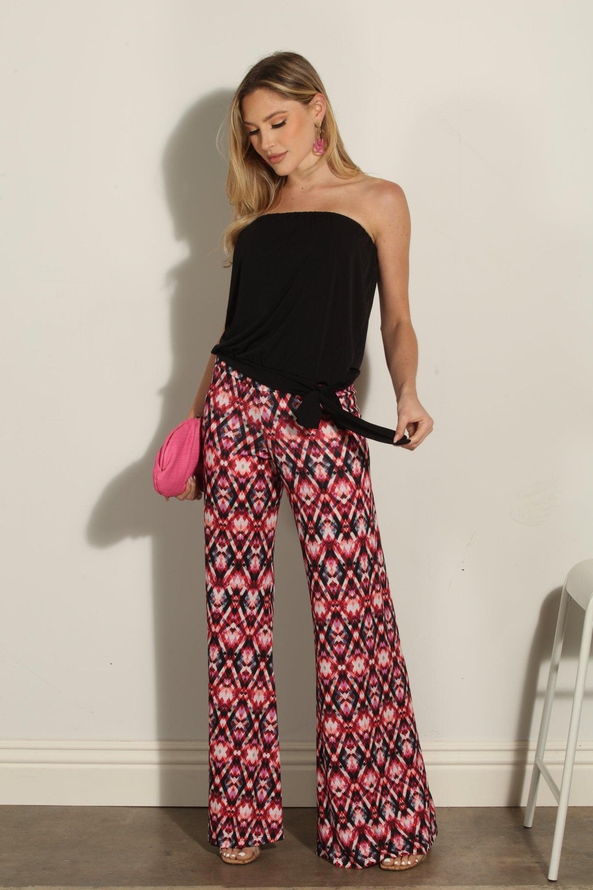 strapless top and multicolored pants on woman holding pink clutch