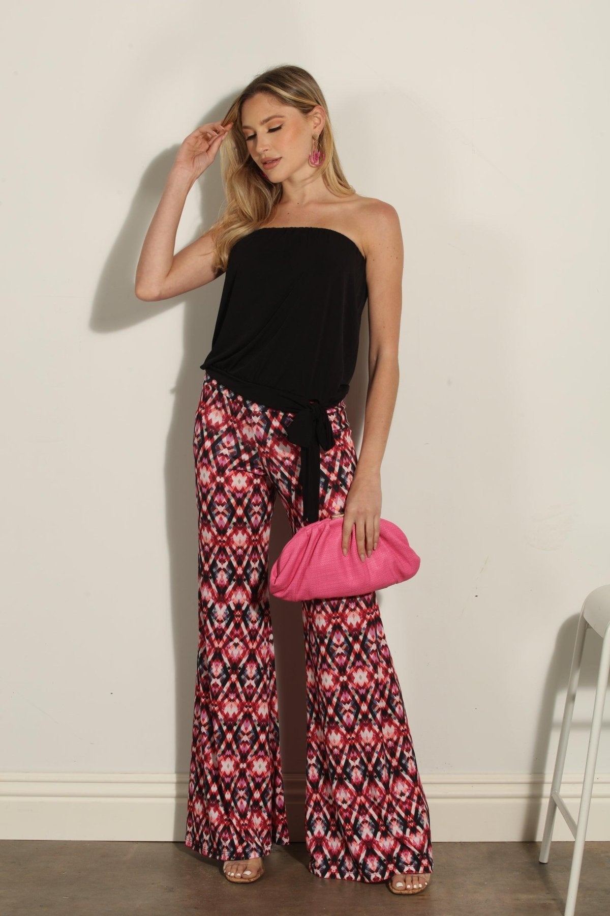 strapless top and multicolored pants on woman holding pink clutch