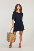 navy dress with sleeves on woman holding multicolored tote bag