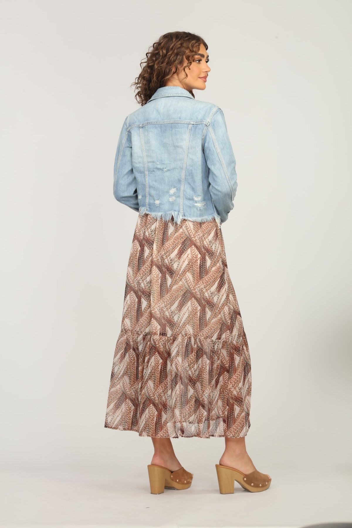 backside of multicolored maxi dress and jean jacket on woman
