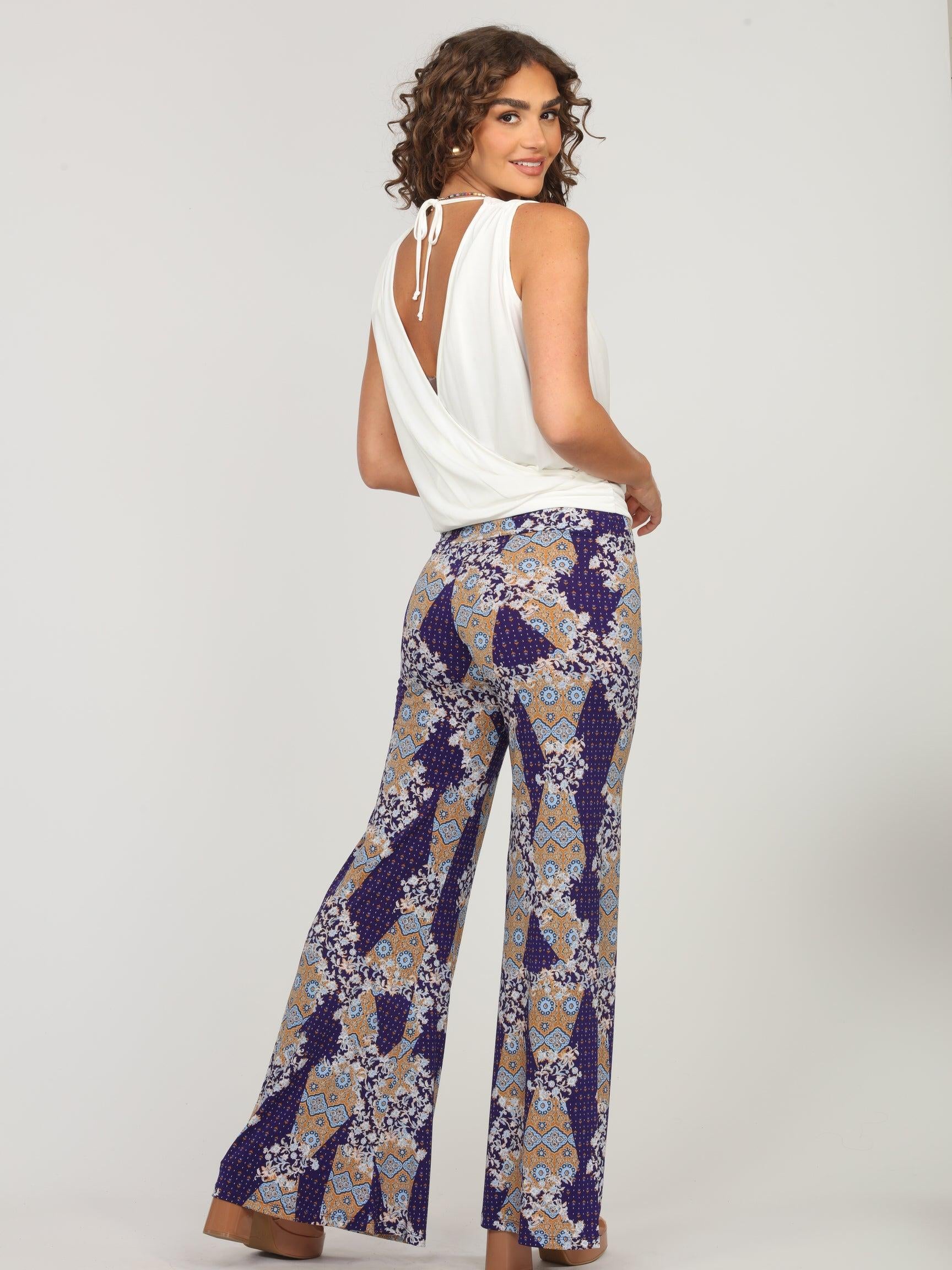 back side of white sleeveless blouse and multicolored, printed, wide-legged pants on woman