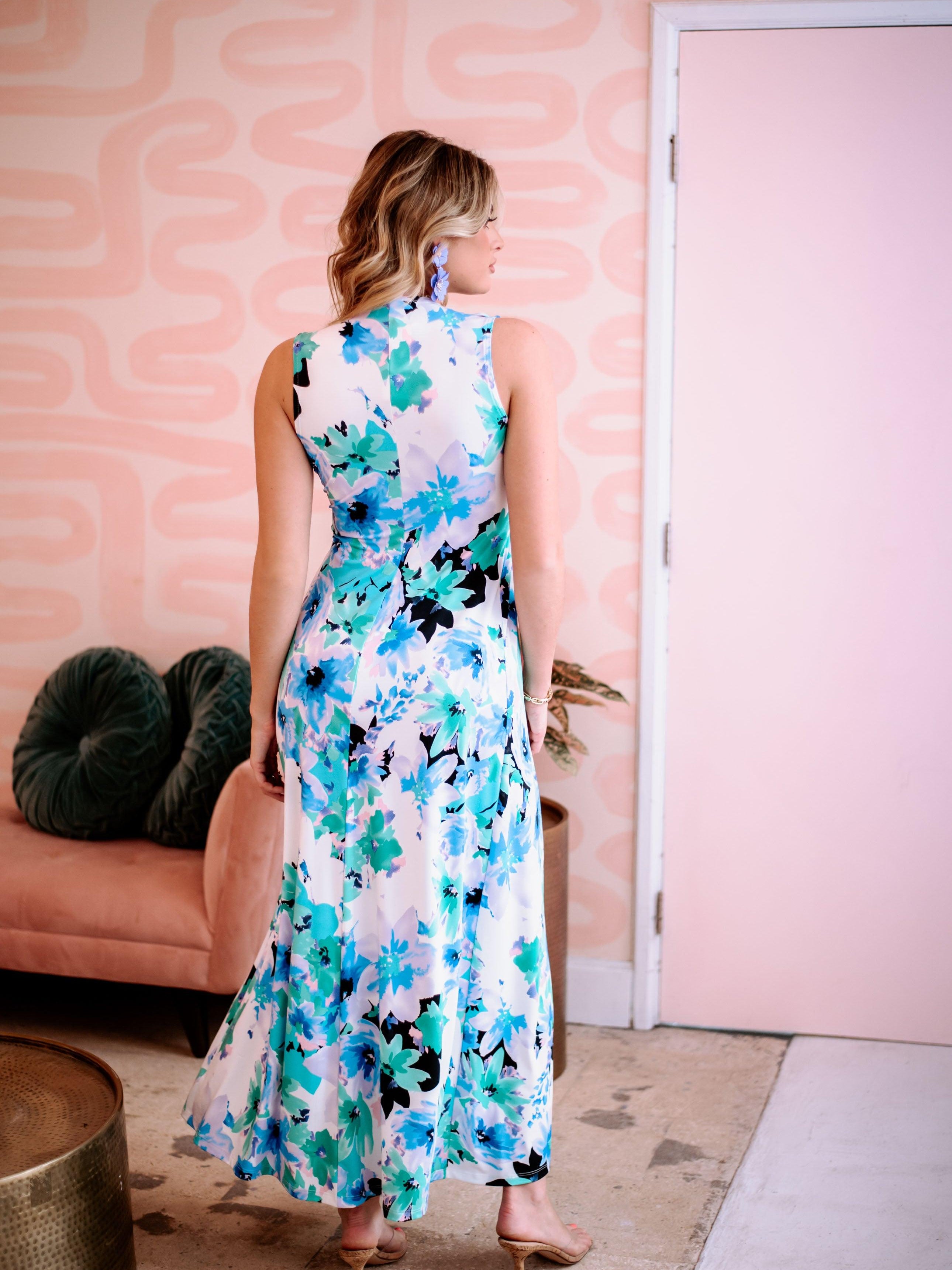 back side of multicolored sleeveless maxi dress on woman with purple earrings