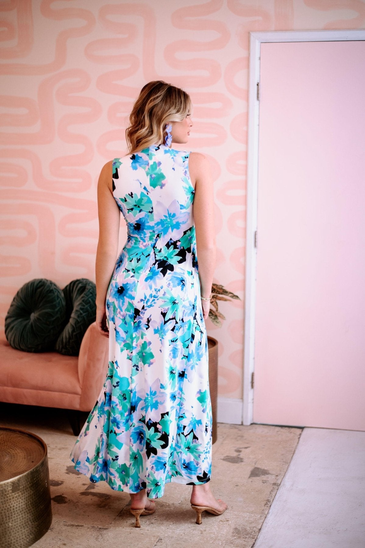 back side of multicolored sleeveless maxi dress on woman with purple earrings