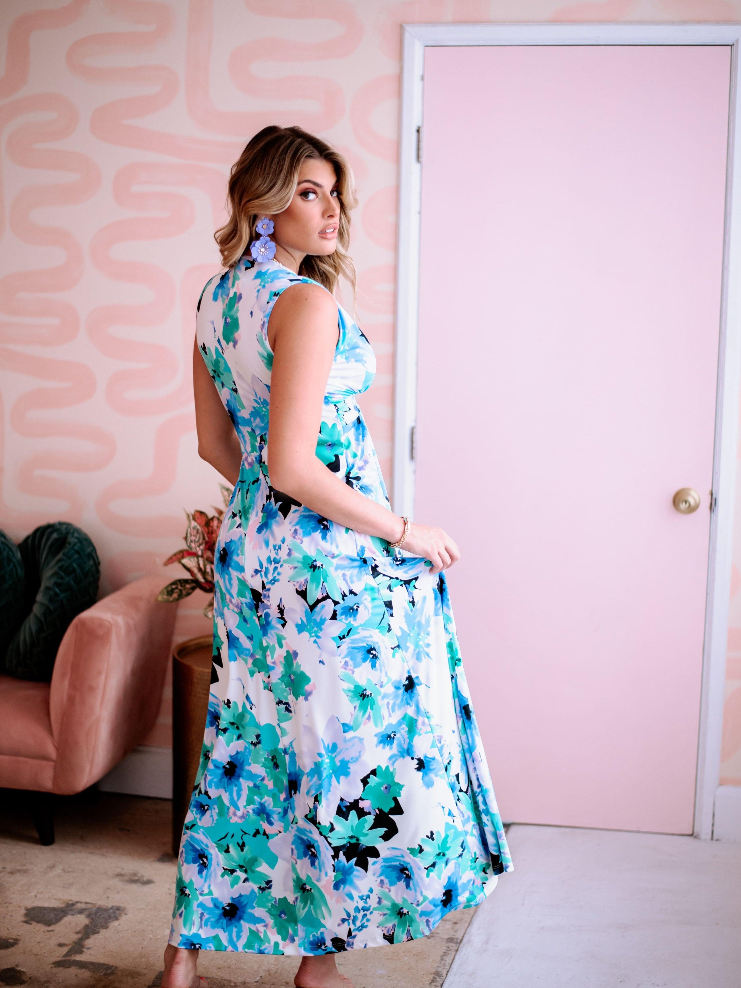 backside of multicolored sleeveless maxi dress on woman with purple earrings