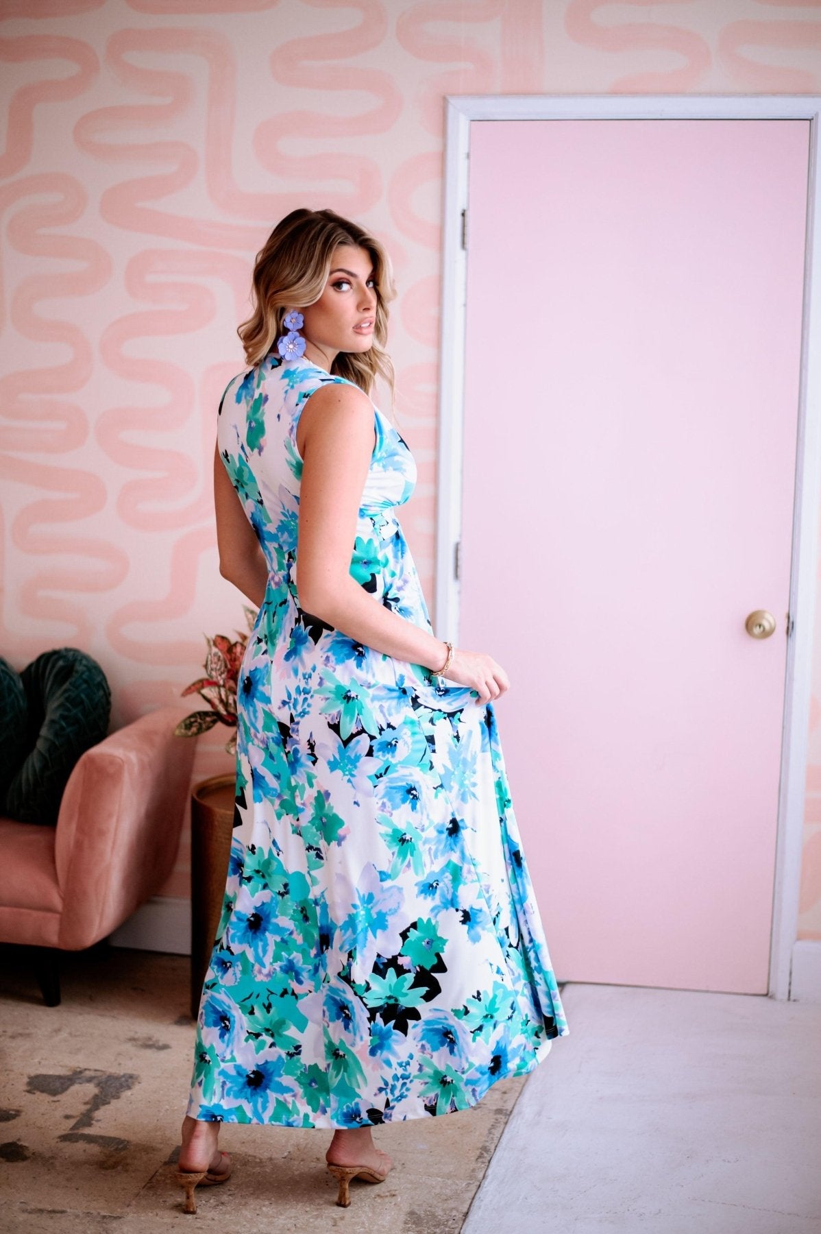 backside of multicolored sleeveless maxi dress on woman with purple earrings