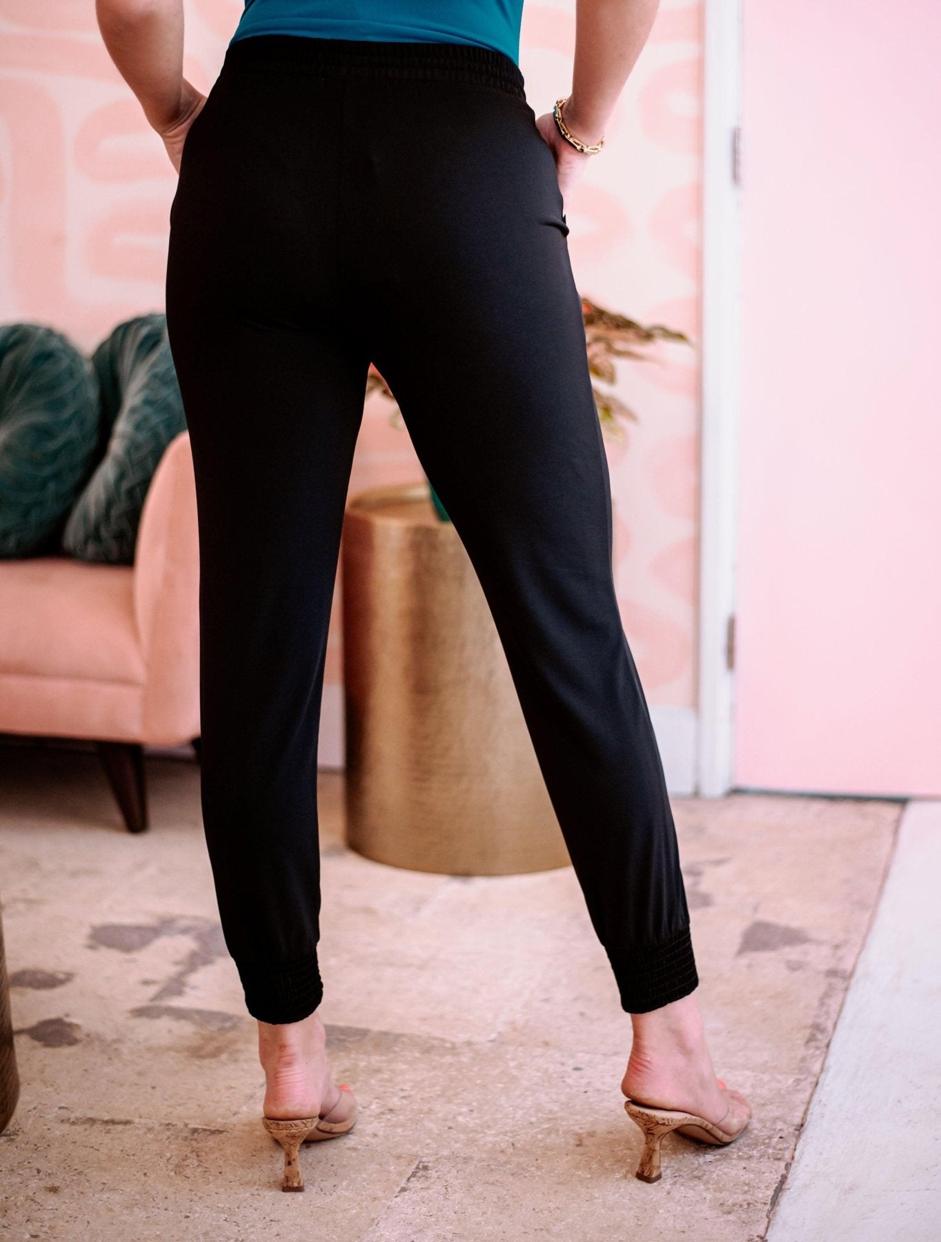 back side of black tapered jogger pants on woman in high heels