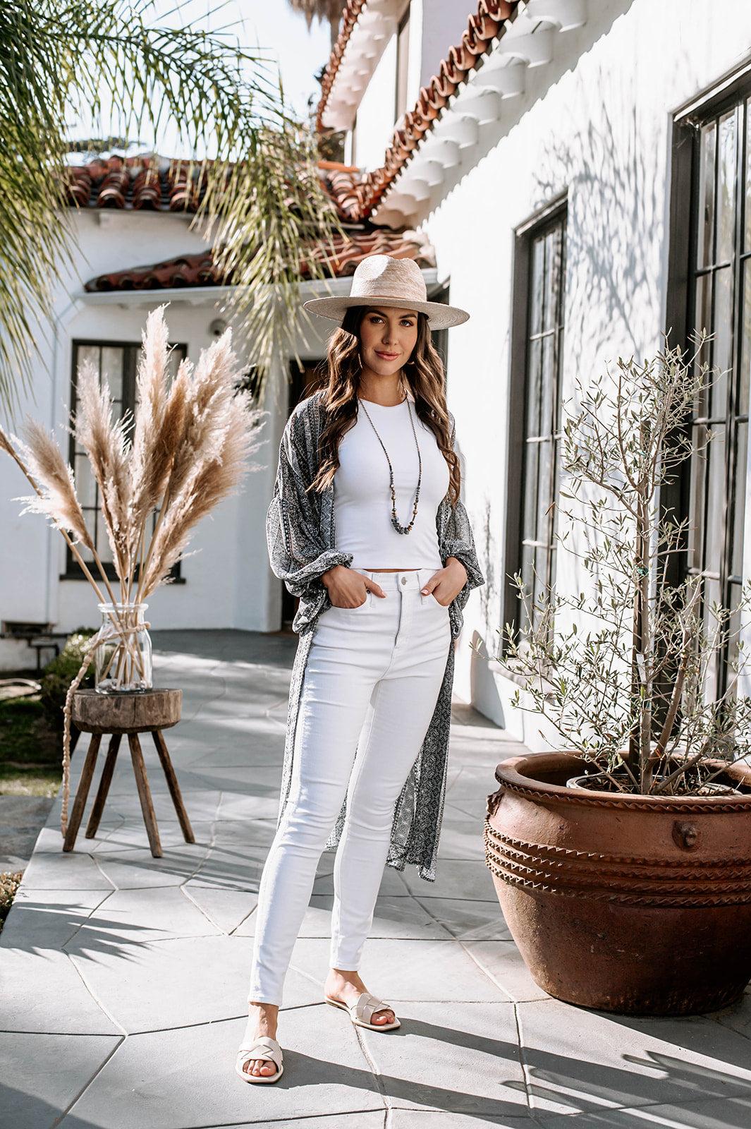 white sleeveless top and blue open kimono on woman in white denim pants
