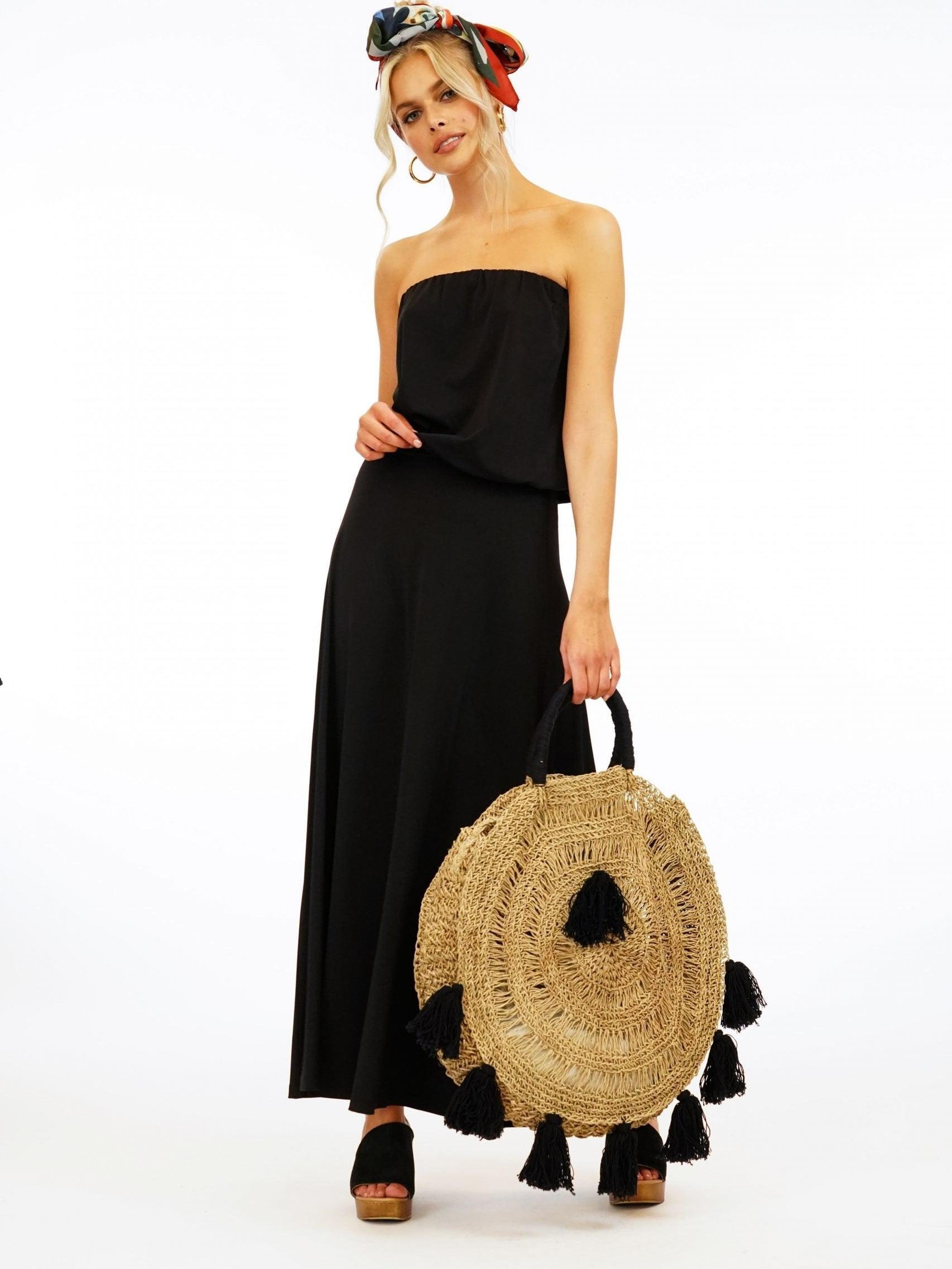 black strapless maxi dress on woman holding large purse