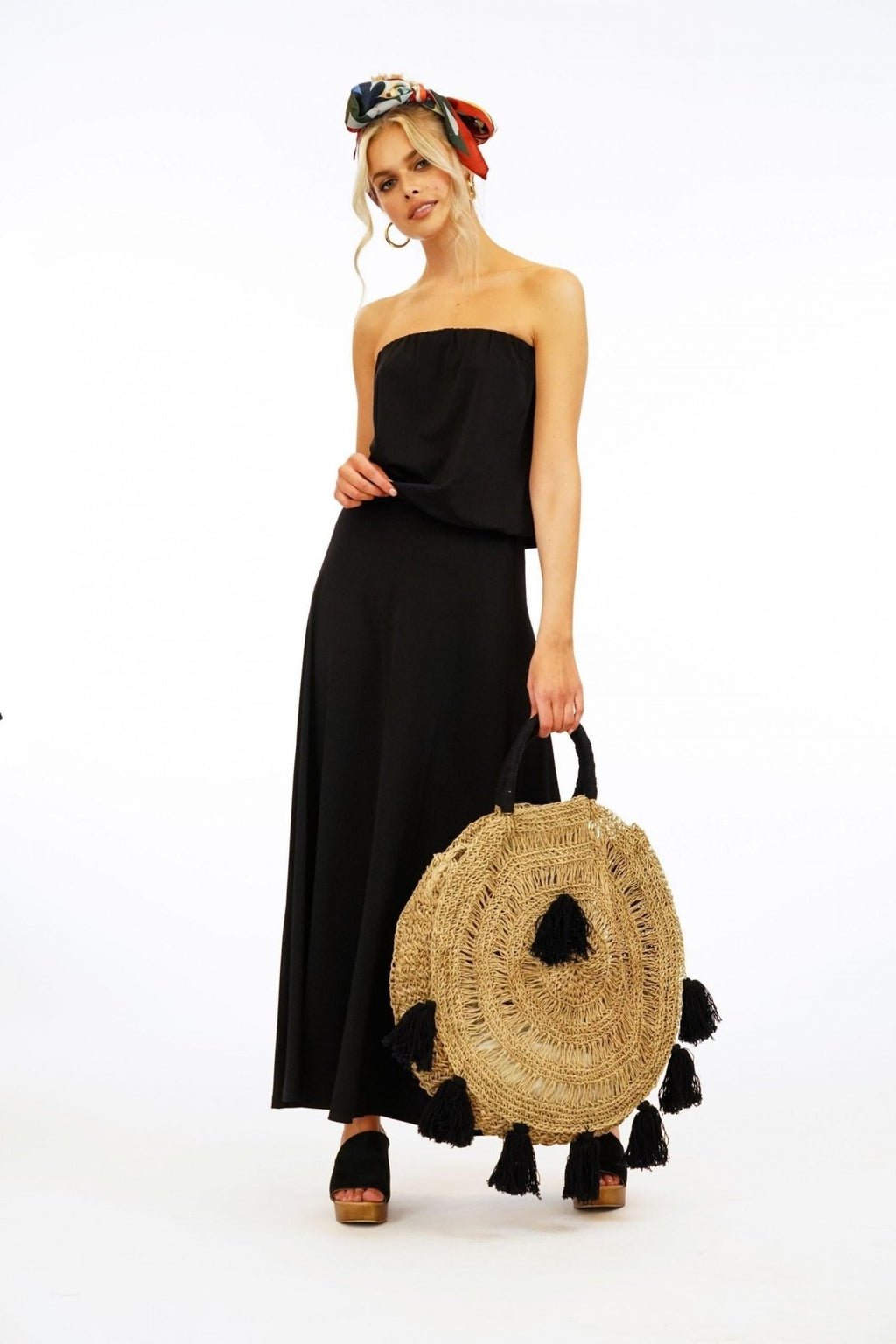 black strapless maxi dress on woman holding large purse