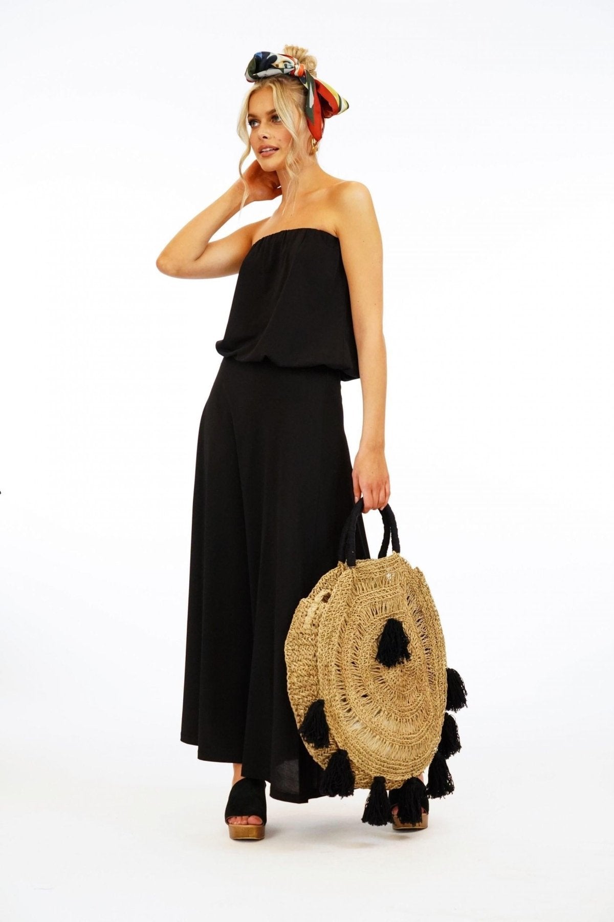 black strapless maxi dress on woman holding large purse