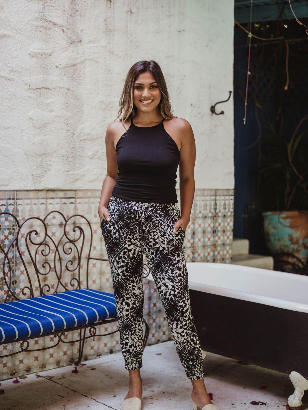 black sleeveless tank top and printed tapered pants on woman