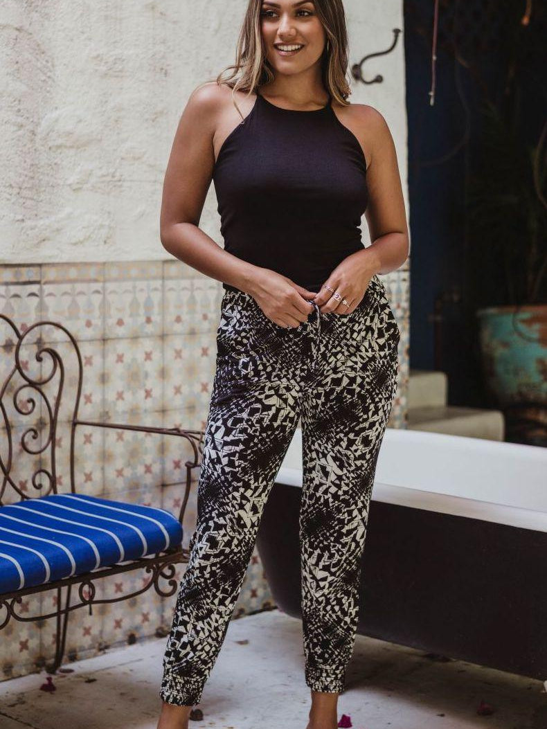 black sleeveless tank top and printed tapered pants on woman