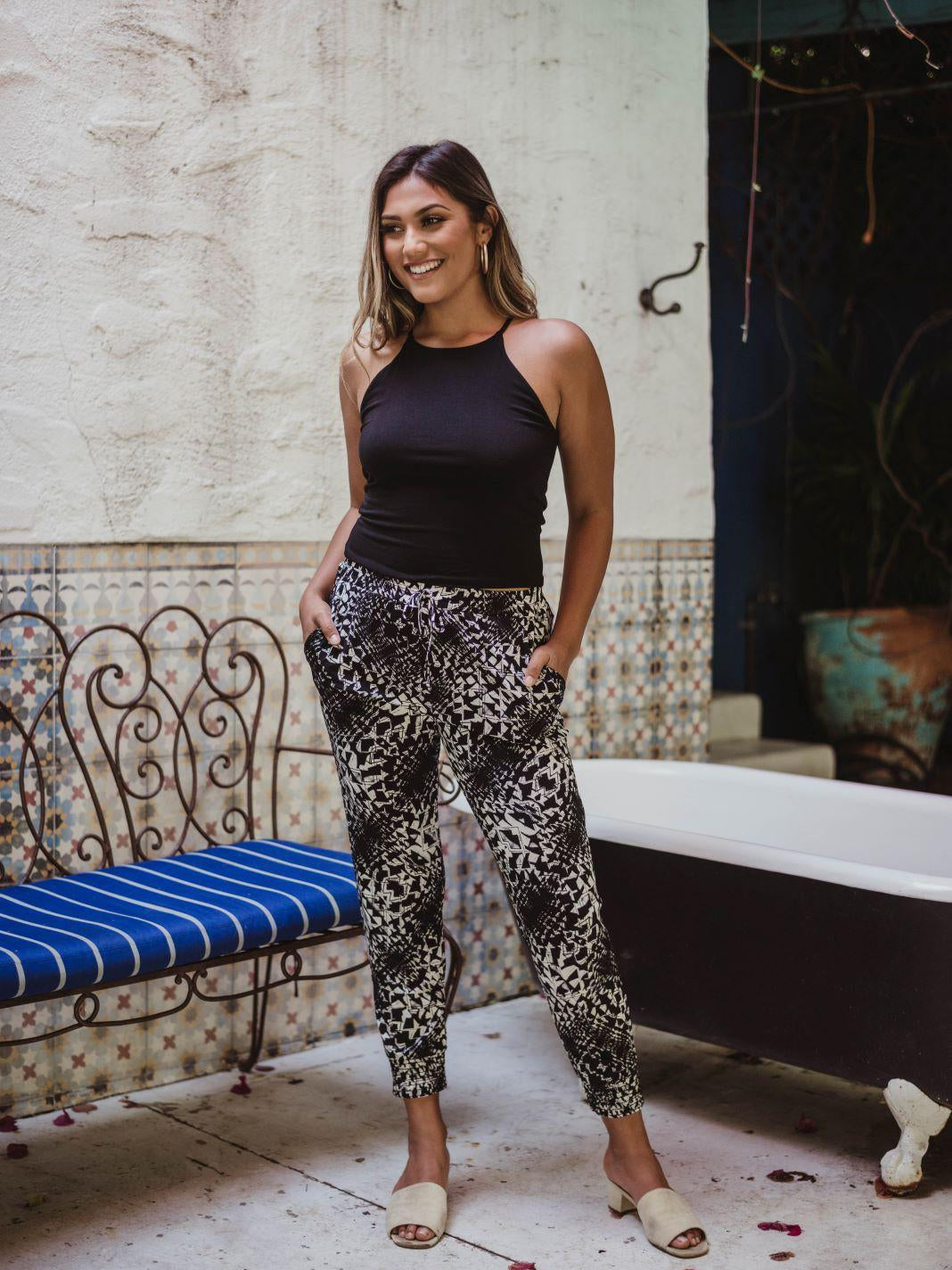 black sleeveless tank top and printed tapered pants on woman