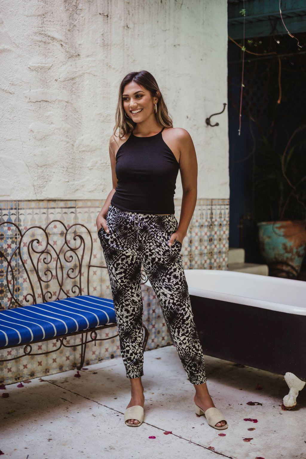 black sleeveless tank top and printed tapered pants on woman