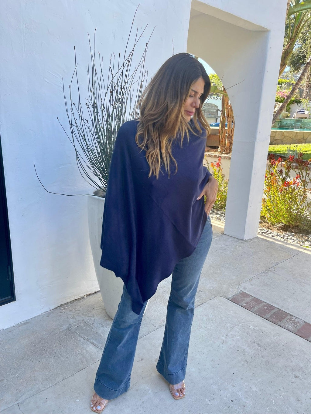 navy poncho and dark denim on woman