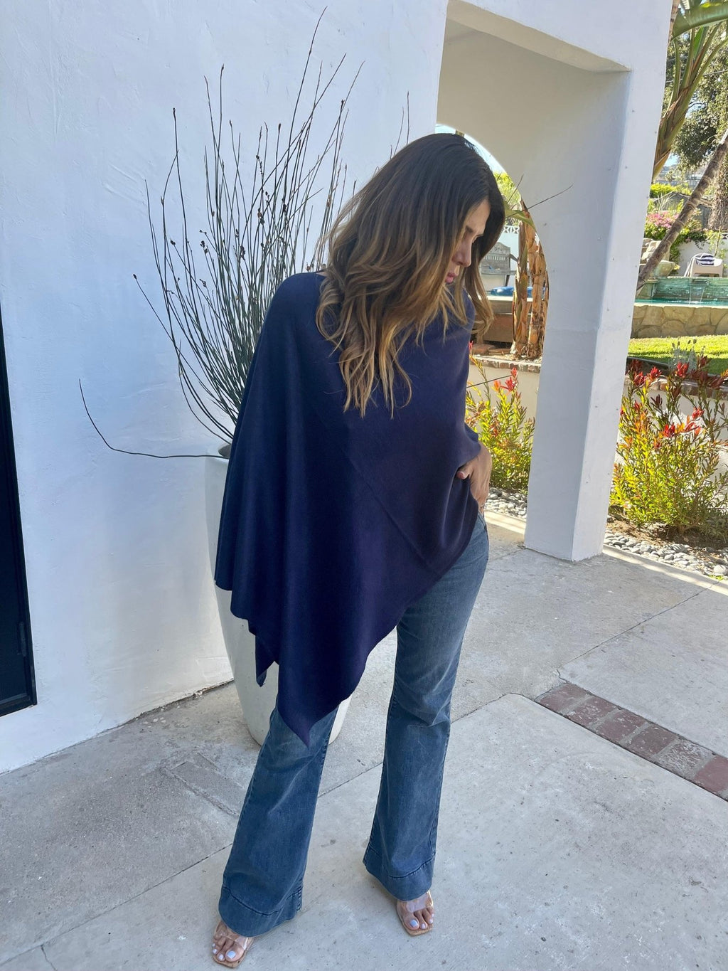 navy poncho and dark denim on woman