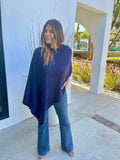 navy poncho and dark denim on woman