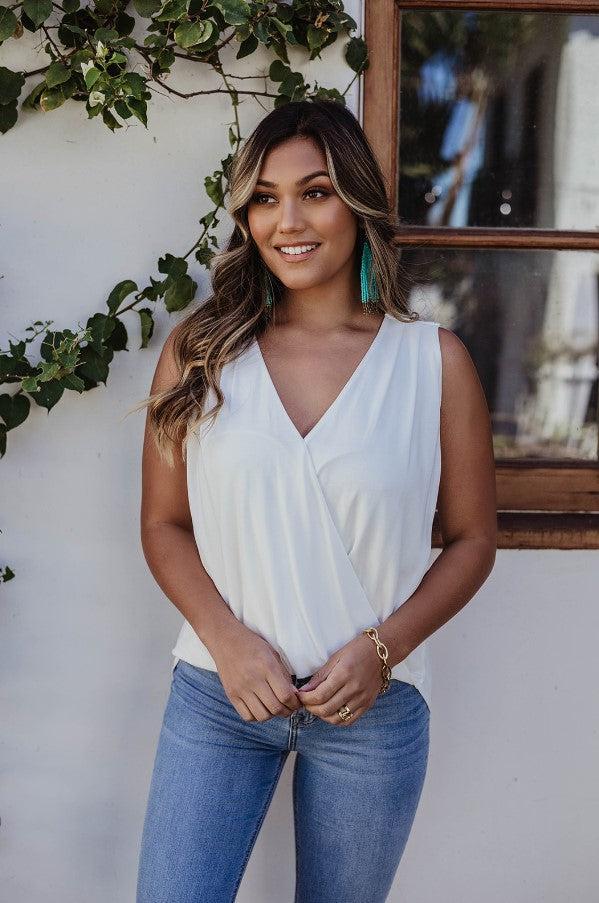 ivory sleeveless blouse on woman in denim pants