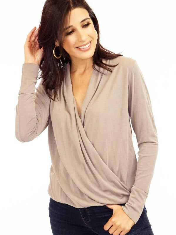 tan long sleeve draped blouse on woman in denim pants